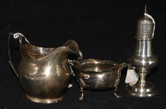 A George III silver cream jug, a similar cream boat and a small sugar caster